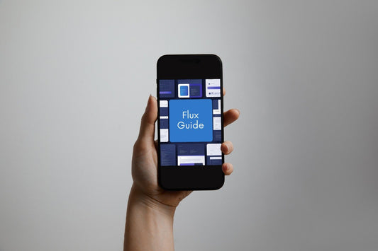 A hand holding a black smartphone that displays a digital guide titled 'Flux Guide' on its screen against a plain gray background.