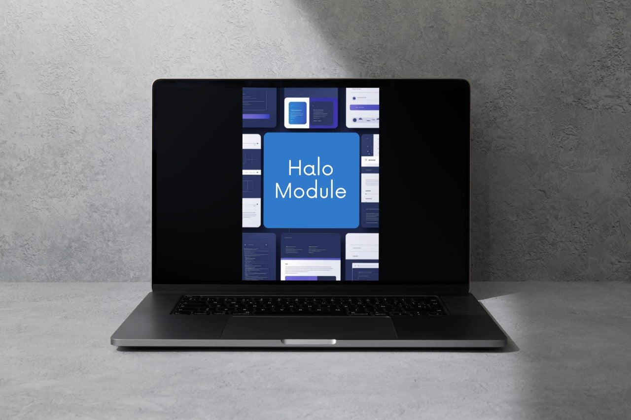 A dark gray laptop sits open on a light gray surface against a textured gray wall, with the screen displaying a blue and white interface labeled 'Halo Module'.